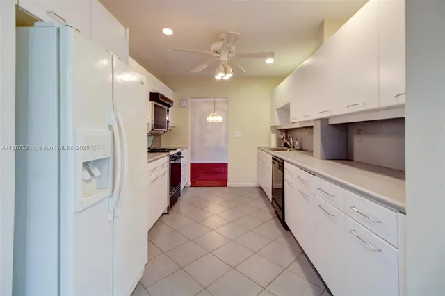 a large kitchen with a large counter top stainless steel appliances and cabinets