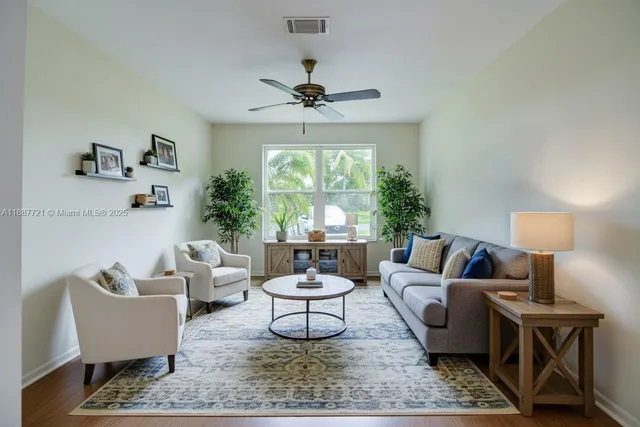 a living room with furniture a chandelier and a window