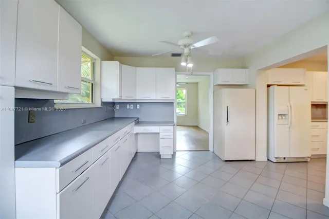 a large kitchen with cabinets and a window