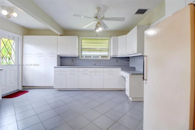 a kitchen with cabinets appliances a sink and a counter top space