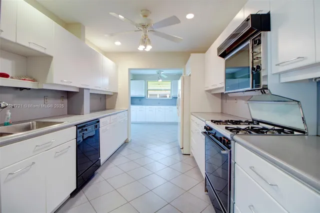 a kitchen with stainless steel appliances a stove a sink and a microwave