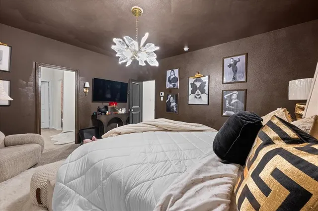 a bed room with a bed mirror and a chandelier