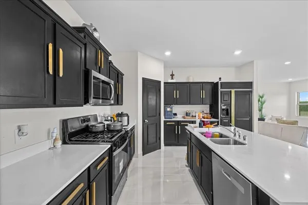 a kitchen with a sink stove top oven and refrigerator