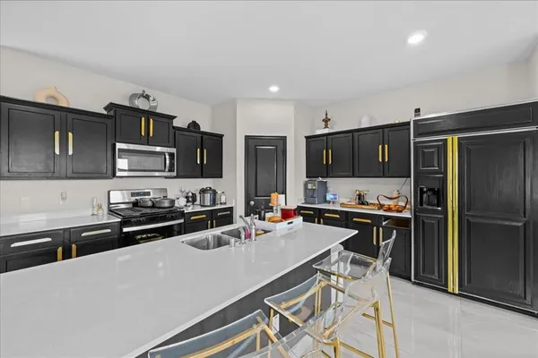 a kitchen with stainless steel appliances a stove refrigerator sink and microwave