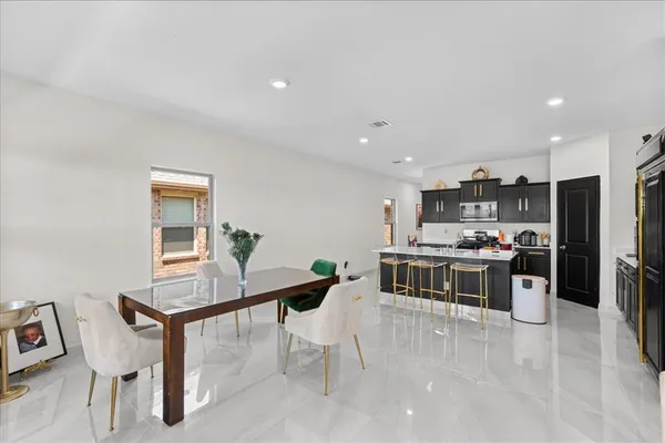 a kitchen with kitchen island a stove a table and chairs in it