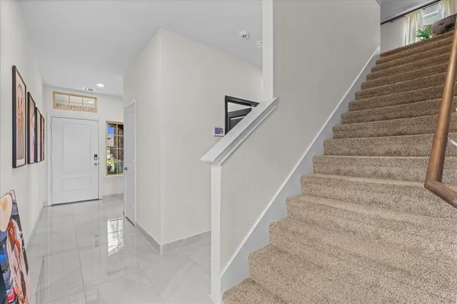 a view of staircase with lots of frames on wall