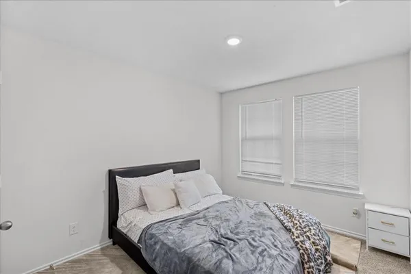 a bed sitting in a bedroom next to a cabinet