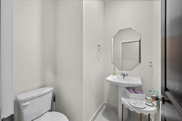 a bathroom with a toilet a sink and mirror