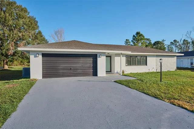 front view of a house with a yard and an trees