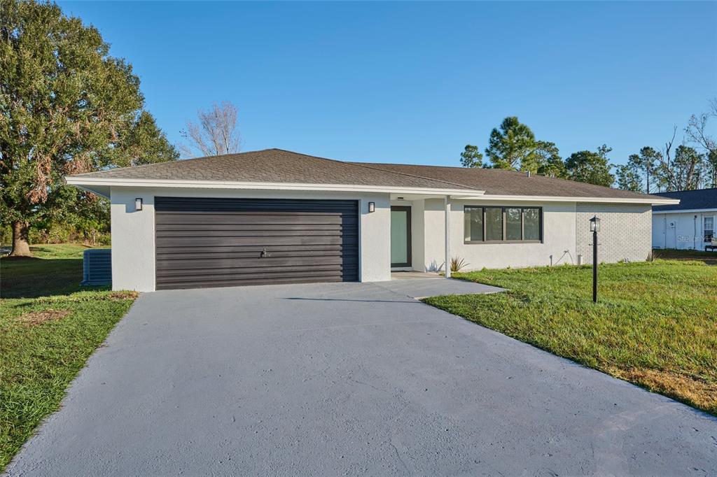 front view of a house with a yard and an trees