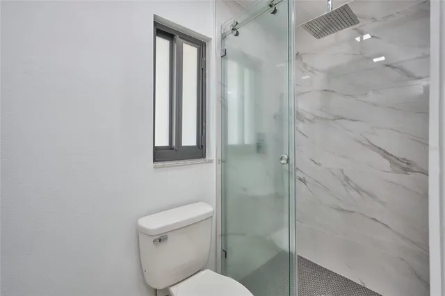 a bathroom with a toilet and a shower