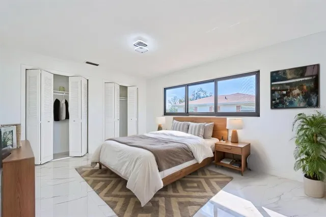 a bedroom with a large bed and a potted plant