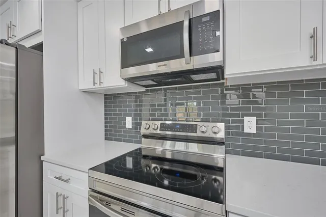 a kitchen with a stove and white cabinets