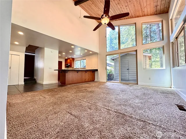 en empty room with windows and ceiling fan