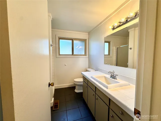a bathroom with a sink and mirror with toilet