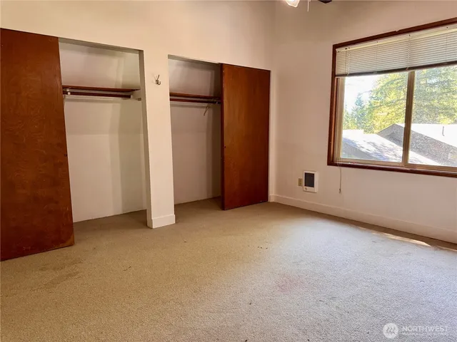 an empty room with windows and closet