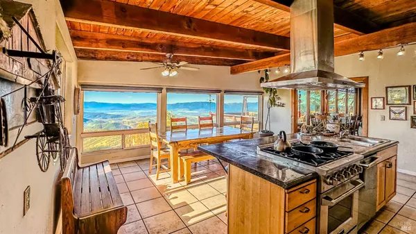 a kitchen with stainless steel appliances granite countertop a stove and a dining table