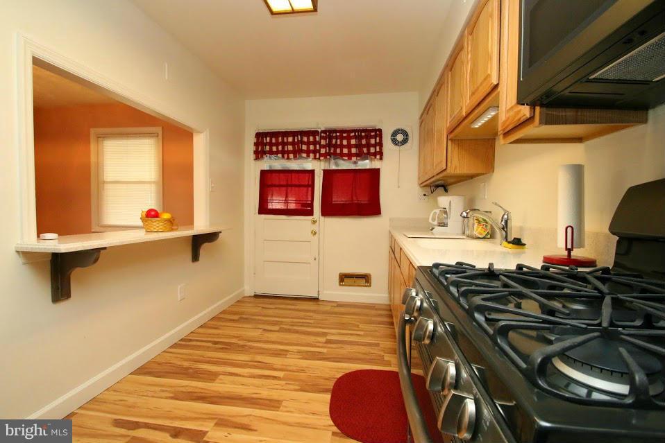 1711 Stokesley Road Baltimore, MD 21222 - Photo 8 of 30 a kitchen with a stove and a microwave