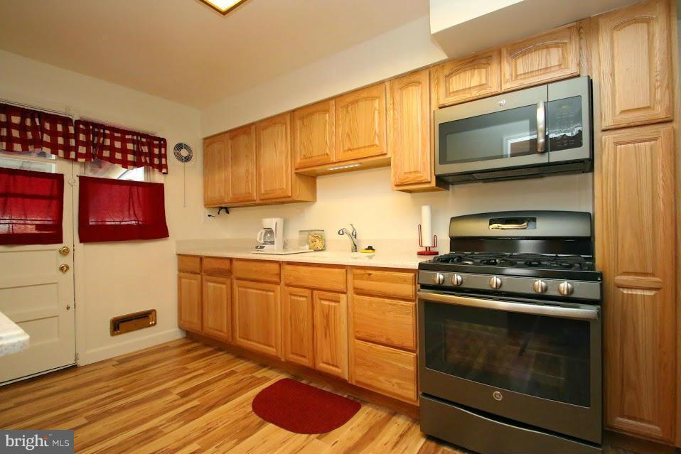 1711 Stokesley Road Baltimore, MD 21222 - Photo 10 of 30 a kitchen with stainless steel appliances granite countertop a stove top oven microwave and cabinets