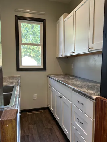 a kitchen with granite countertop white cabinets and white appliances