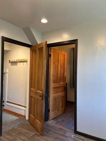 a view of a hallway with closet and wooden floor