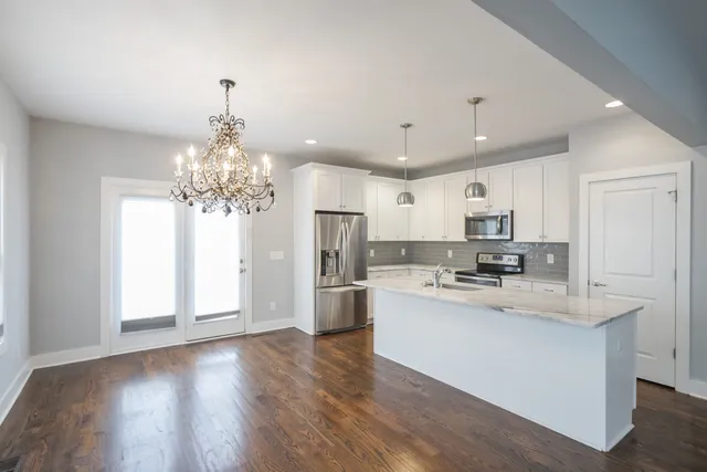 an empty room with wooden floor and a ceiling fan