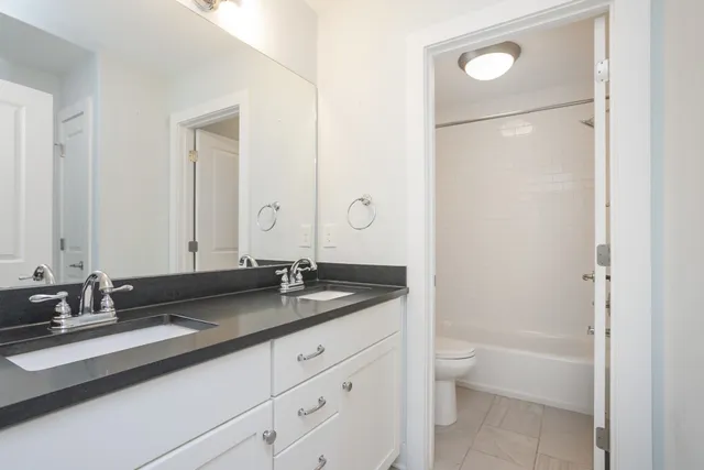 a kitchen with granite countertop a sink a stove and refrigerator