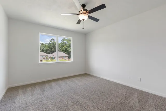 a view of an empty room with a ceiling fan