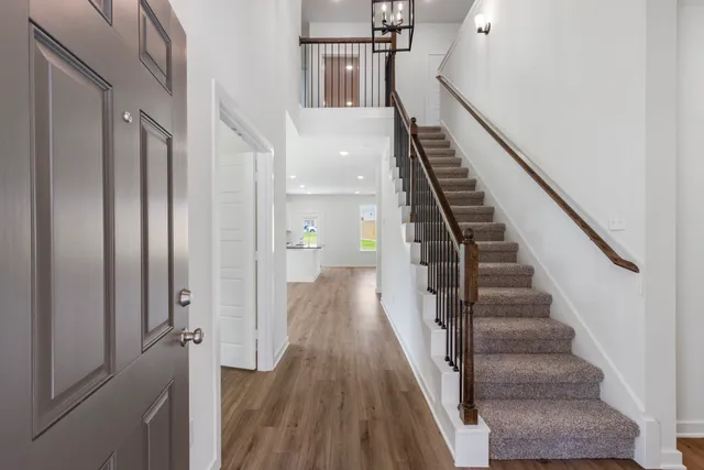 a view of a hallway with wooden floor and entryway