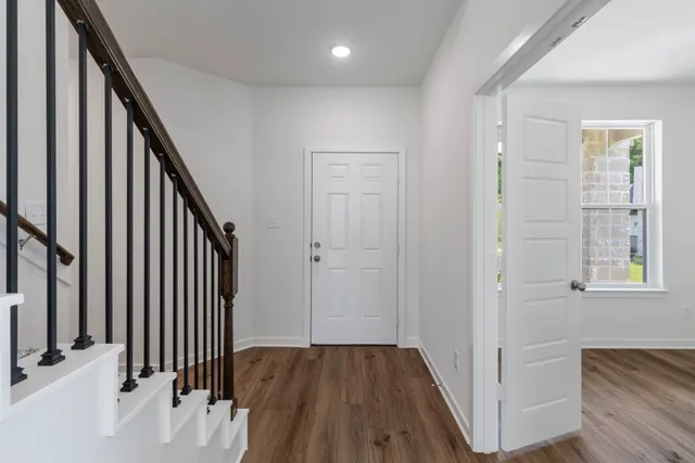 an entryway with wooden floor and stairs