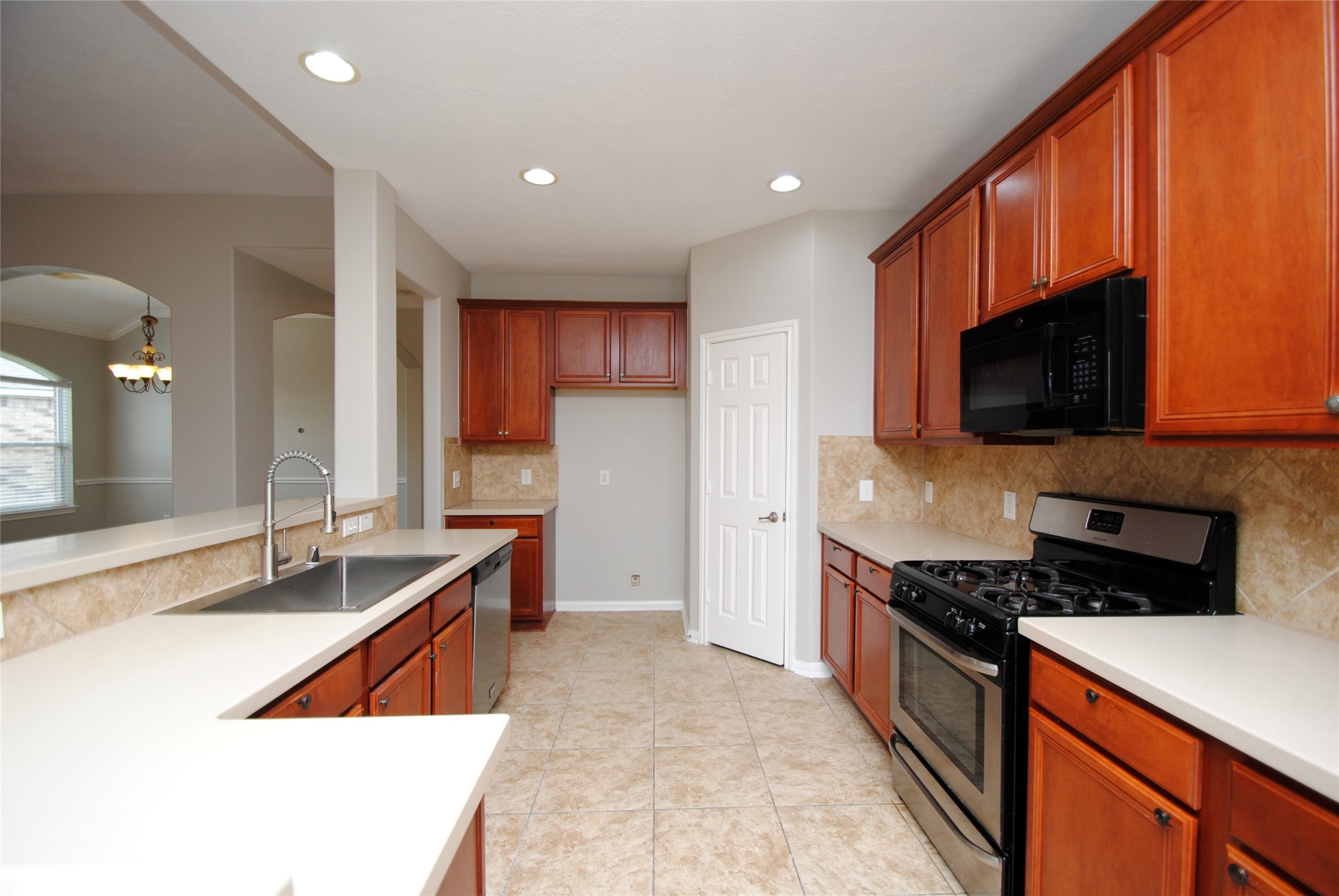 13409 Garden Spring Court Rosharon, TX 77583 - Photo 11 of 38 a kitchen with stainless steel appliances granite countertop a sink and a stove
