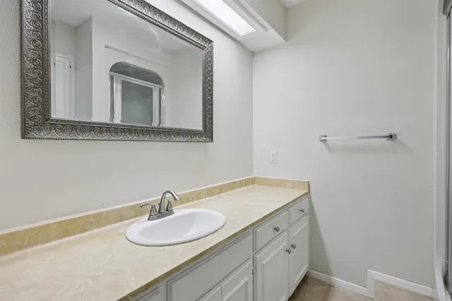 a bathroom with a granite countertop sink and a mirror