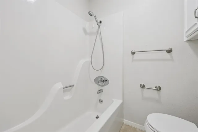 a bathroom with a bath tub with toilet