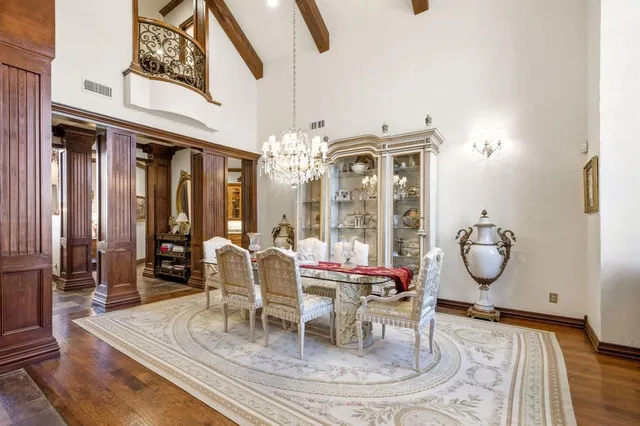 a dining room with chandelier fan and wooden floor