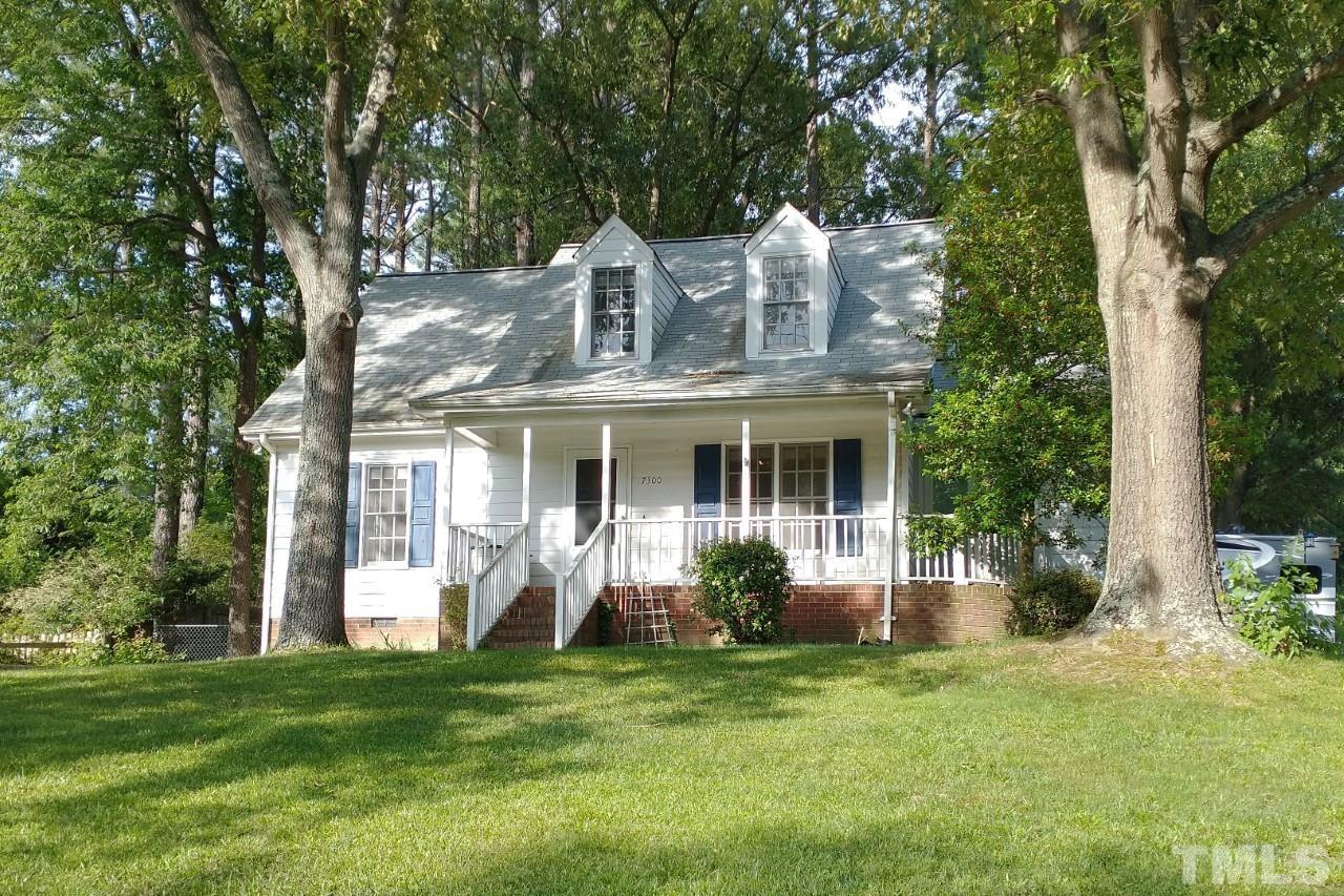 a view of a house with brick walls and a yard with plants