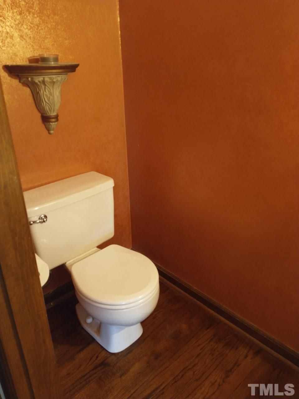 7300 Wilderness Road Raleigh, NC 27613 - Photo 7 of 15 a toilet sitting in a bathroom next to a wooden wall