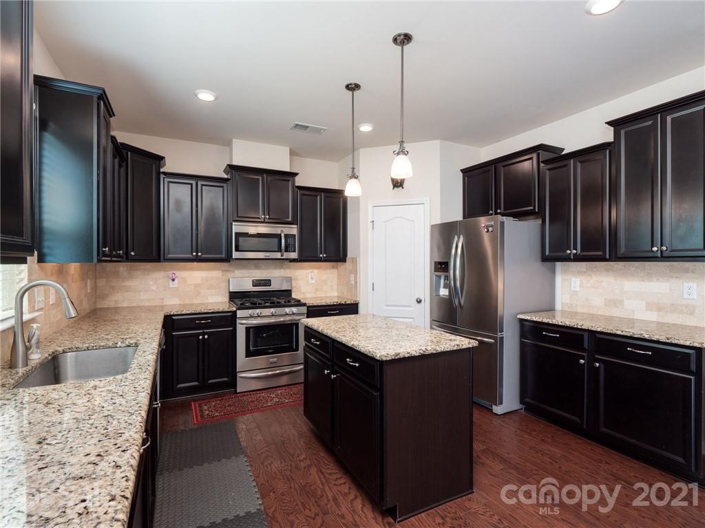 79157 Ridgehaven Road, Unit 154 Lancaster, SC 29720 - Photo 11 of 23 a kitchen with stainless steel appliances granite countertop a sink stove and refrigerator