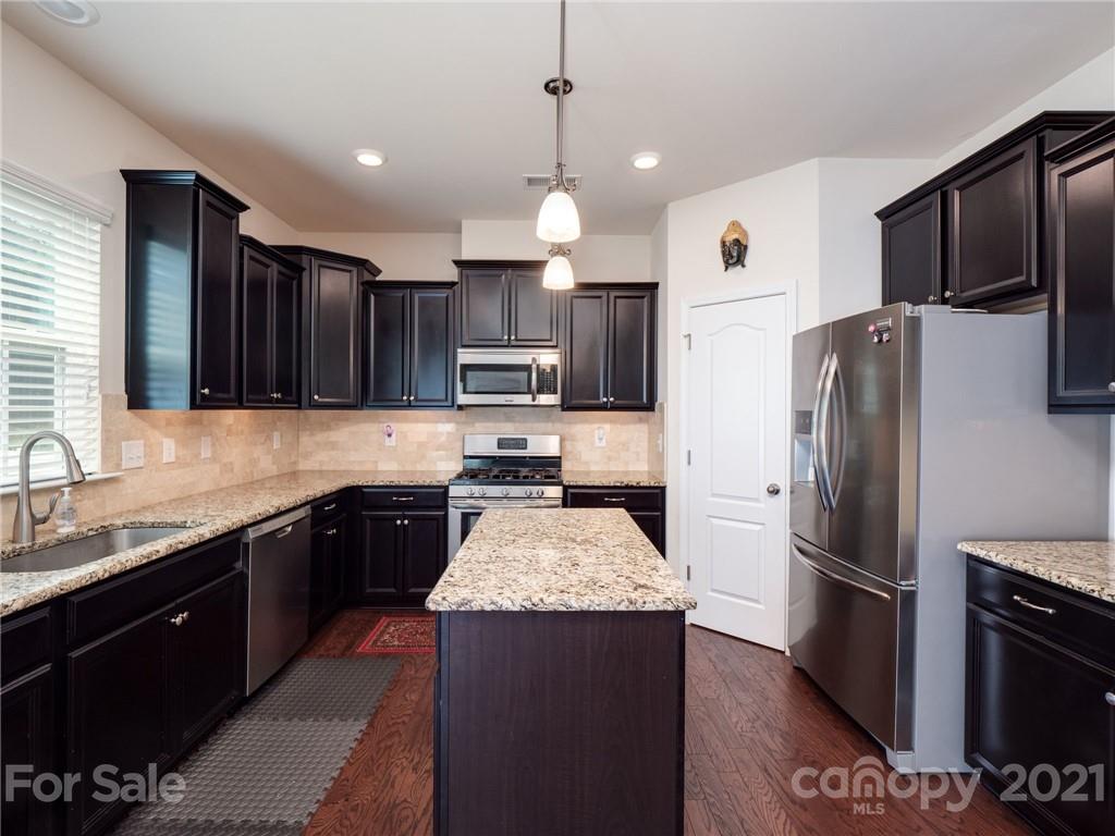 79157 Ridgehaven Road, Unit 154 Lancaster, SC 29720 - Photo 10 of 23 a kitchen with kitchen island granite countertop stainless steel appliances a stove refrigerator a sink and a oven