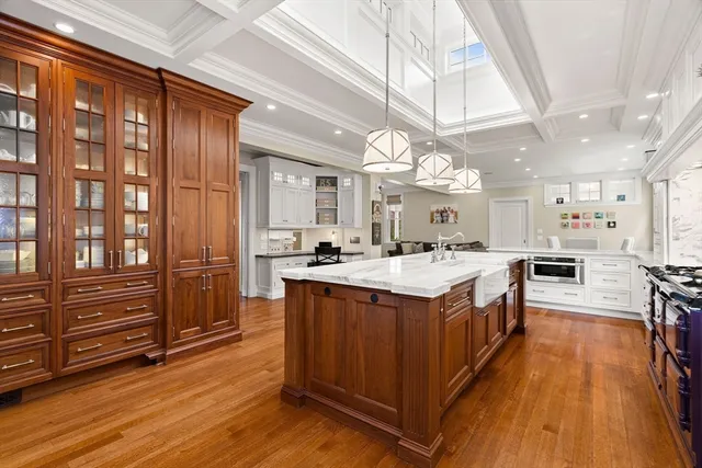 a large kitchen with stainless steel appliances granite countertop a stove and a wooden floors