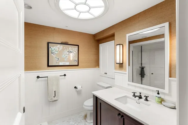 a bathroom with a sink a toilet and a mirror