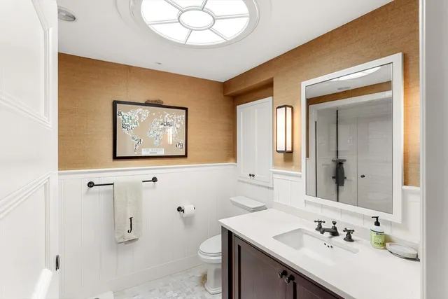 a bathroom with a sink a toilet and a mirror