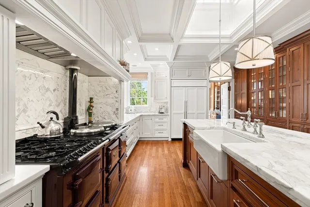 a kitchen with granite countertop a stove a sink and wooden floor