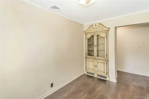 an empty room with wooden floor and cabinet