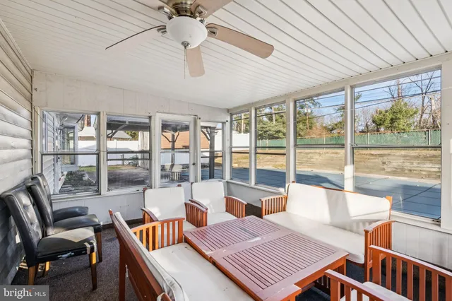 a living room with furniture a ceiling fan and a large window