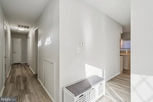 a view of a hallway with wooden floor and staircase
