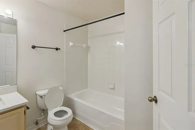 a white toilet sitting next to a bath tub