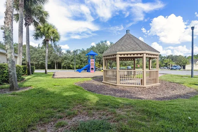 a view of a house with a yard and a large tree