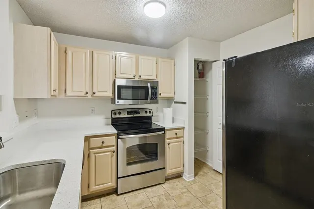 a kitchen with stainless steel appliances white cabinets and a stove top oven