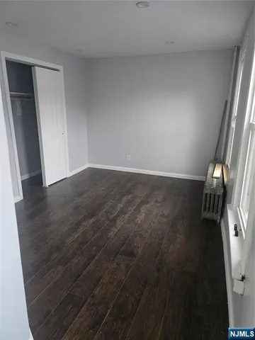 an empty room with wooden floor and a window