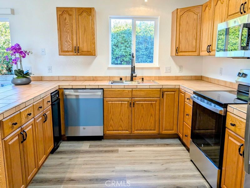 5377 Lancaster Road Lakeport, CA 95453 - Photo 6 of 20 a kitchen with granite countertop a sink cabinets stainless steel appliances and a window